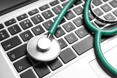 Photo of Stethoscope on laptop, closeup. Concept of technical support