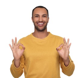 Photo of Smiling African American man showing ok gesture on white background