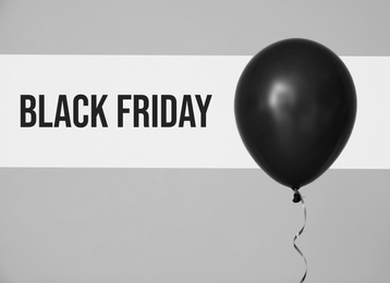 Text BLACK FRIDAY and balloon on color background