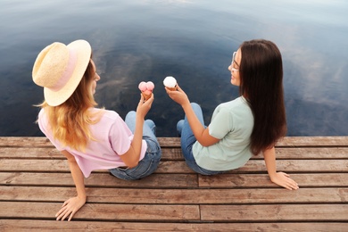 Photo of Young women with ice cream spending time together outdoors