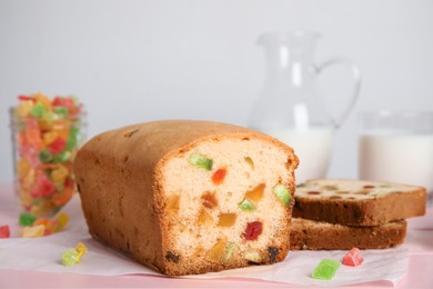 Delicious cake with candied fruits on table