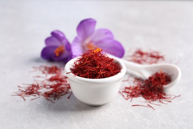 Dried saffron and crocus flowers on grey table, closeup