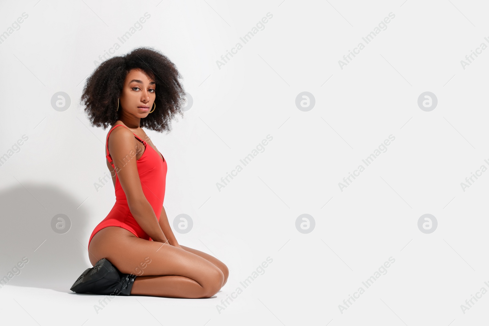 Photo of Beautiful woman in red one-piece summer swimsuit on white background, space for text