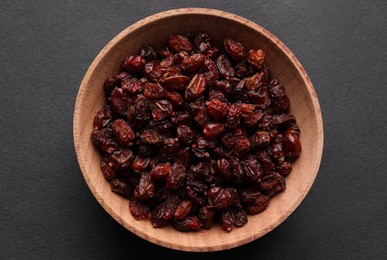 Photo of Dried barberries in wooden bowl on grey background, top view