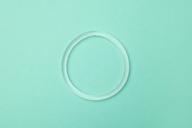 Photo of Diaphragm vaginal contraceptive ring on turquoise background, top view