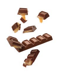 Image of Whole and broken chocolate bars with caramel falling on white background