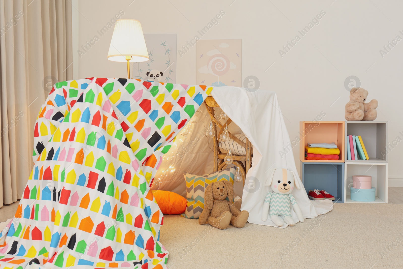 Photo of Play tent decorated with festive lights in modern child's room