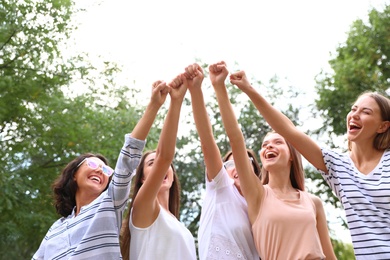 Photo of Happy women raising hands outdoors. Girl power concept