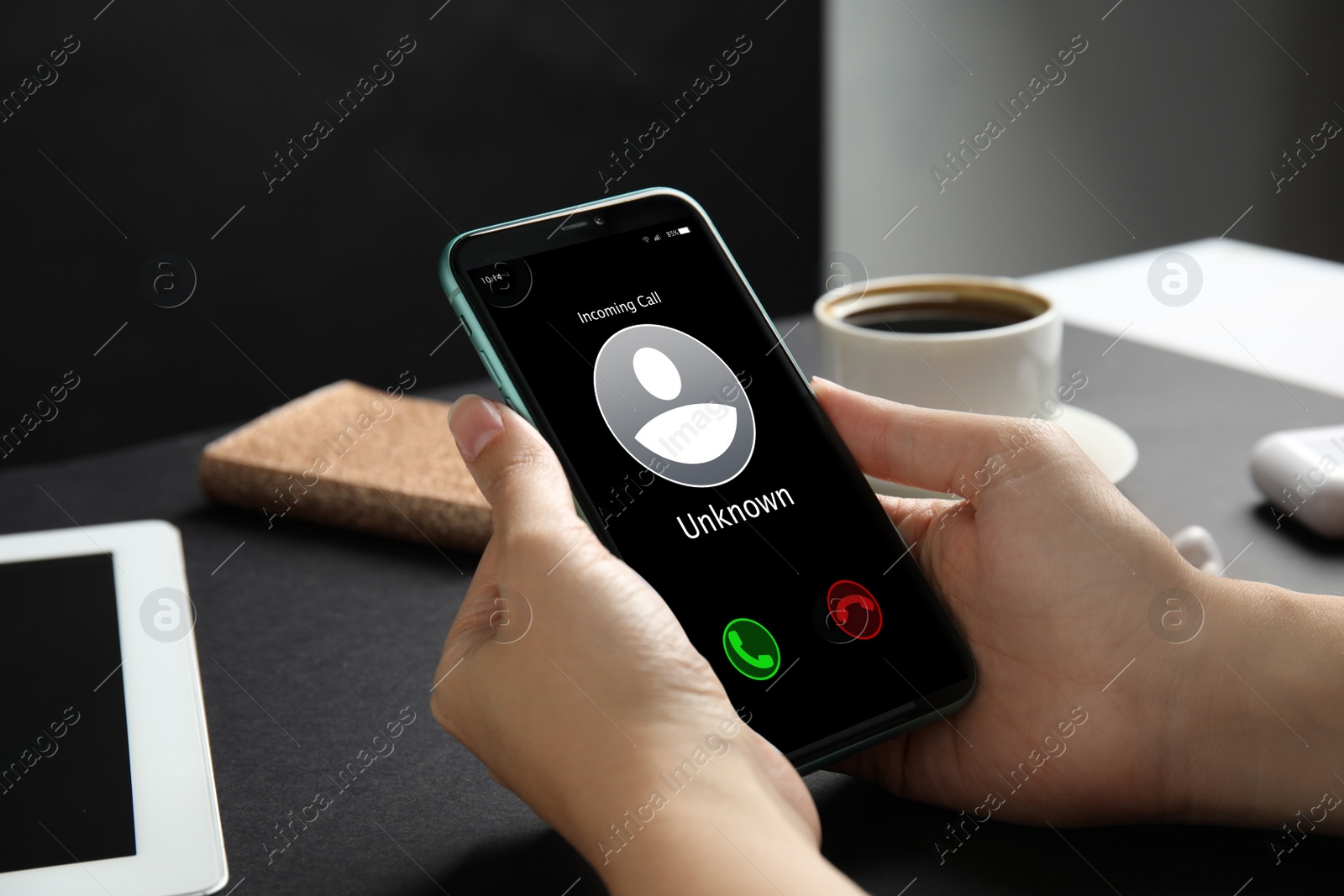 Image of Woman deciding answer incoming call from unknown caller or not at table, closeup. Be careful - fraud