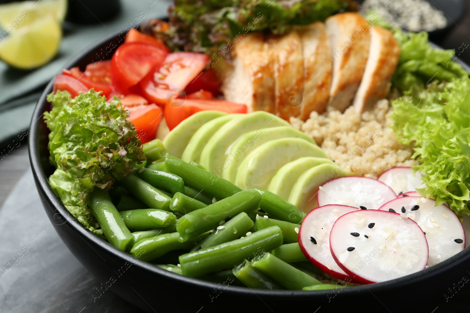 Photo of Healthy meal. Tasty products in bowl on black wooden table, closeup