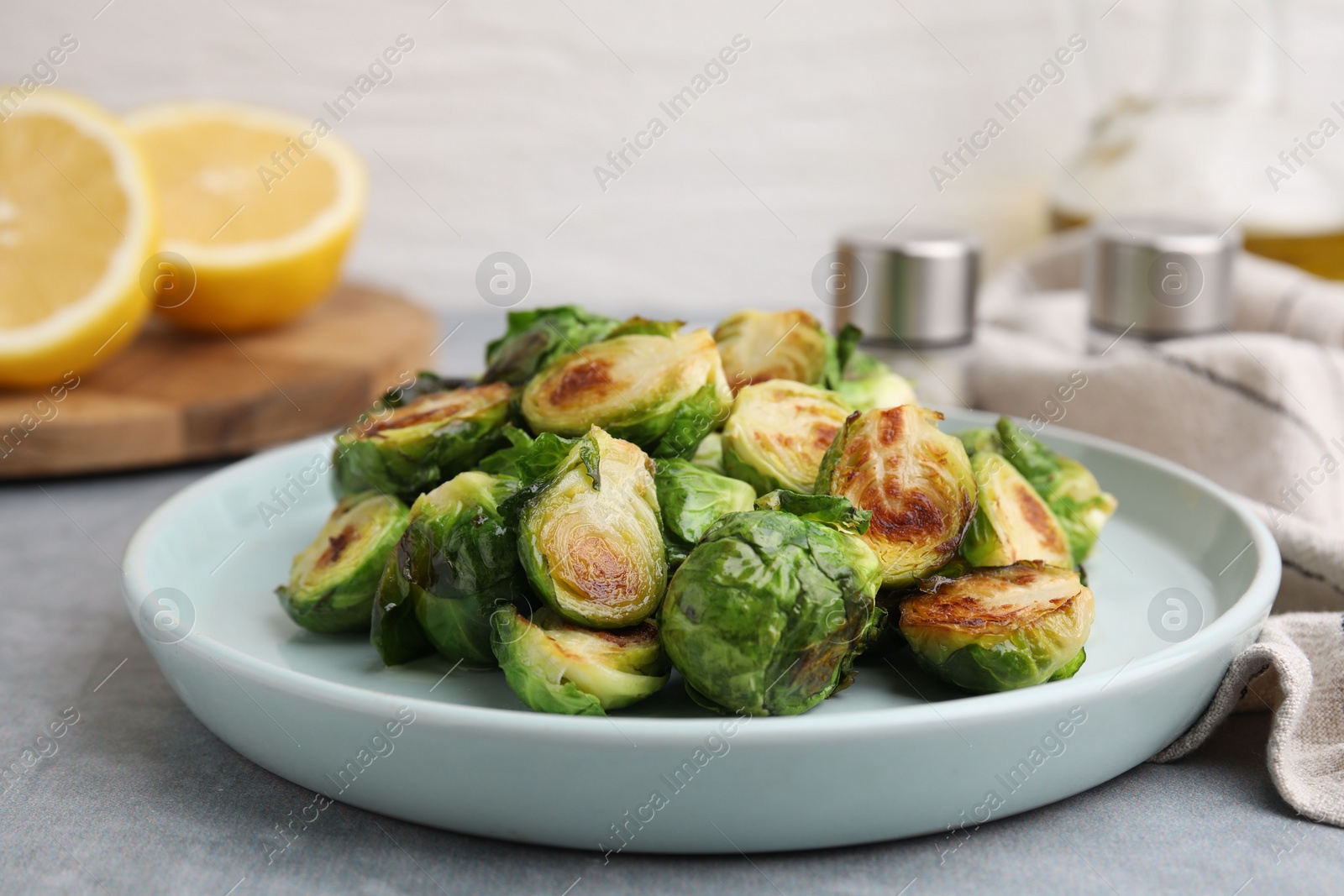 Photo of Delicious roasted Brussels sprouts on grey table, closeup