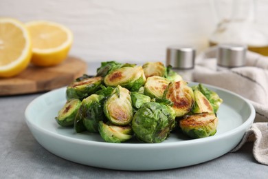 Photo of Delicious roasted Brussels sprouts on grey table, closeup