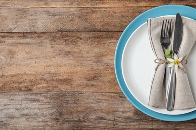 Beautiful table setting on wooden background, flat lay. Space for text