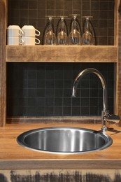 Stylish metal sink in hotel kitchen. Interior design