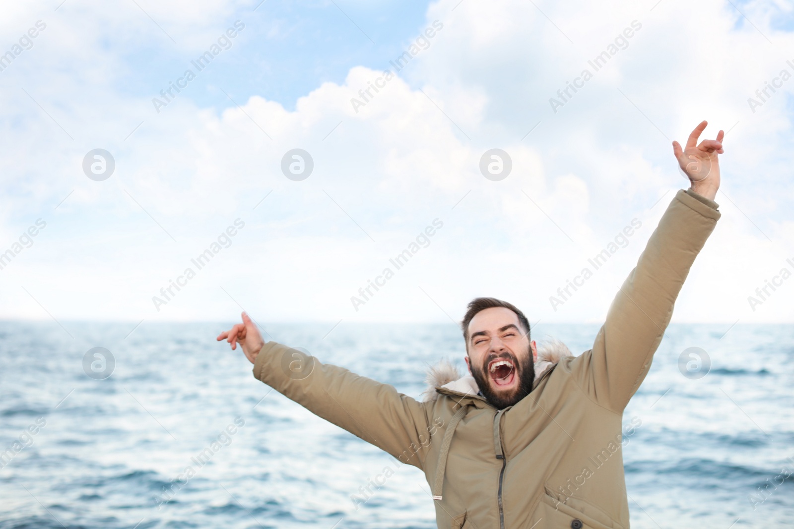 Photo of Stylish young man spending time near sea