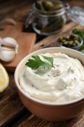 Photo of Tasty tartar sauce and ingredients on table, closeup