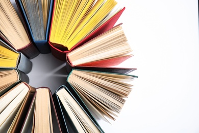 Circle made of hardcover books on white background, flat lay