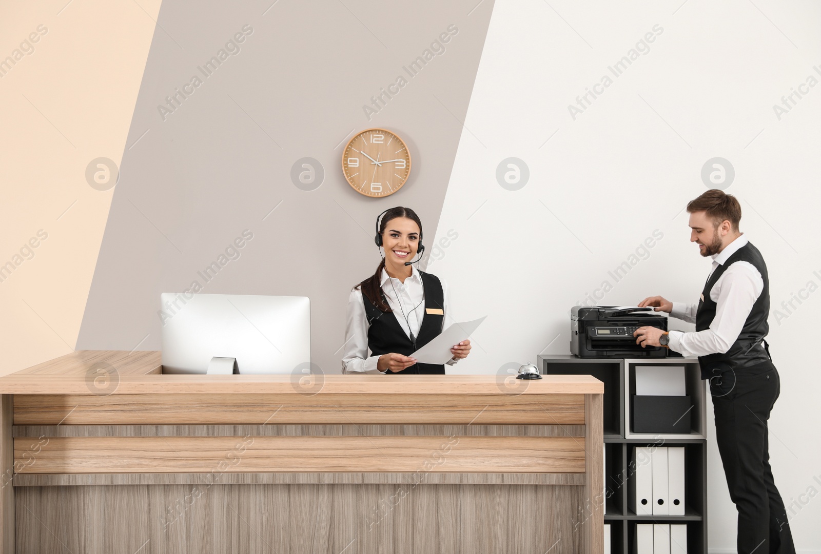 Photo of Young receptionists in professional uniform at workplace