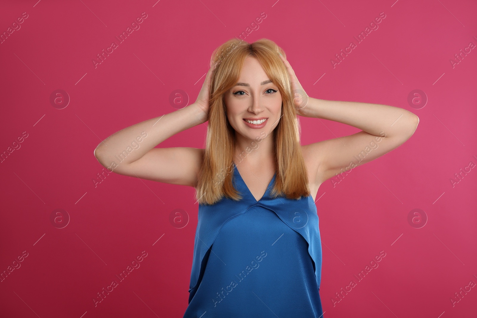 Photo of Beautiful young woman with blonde hair on pink background