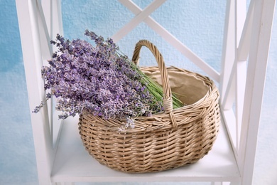 Photo of Wicker basket with lavender flowers on shelf