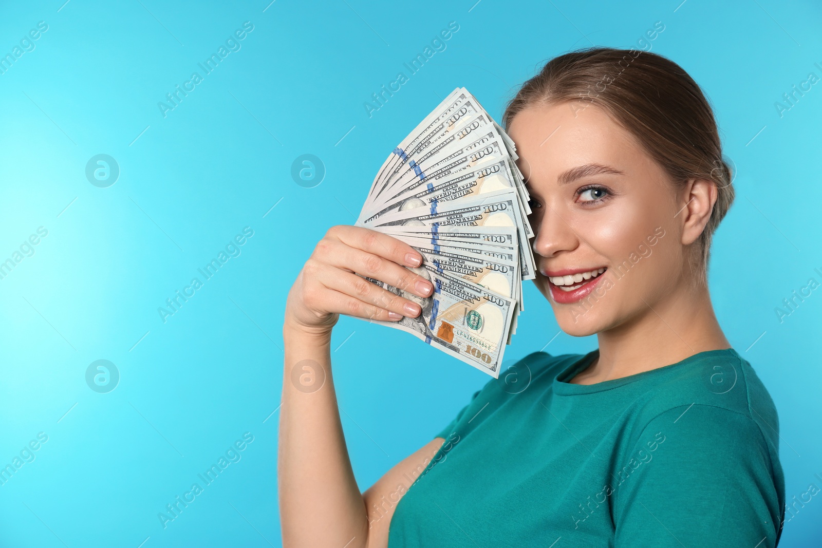 Photo of Portrait of happy young woman with money on color background. Space for text