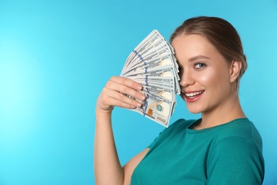 Portrait of happy young woman with money on color background. Space for text