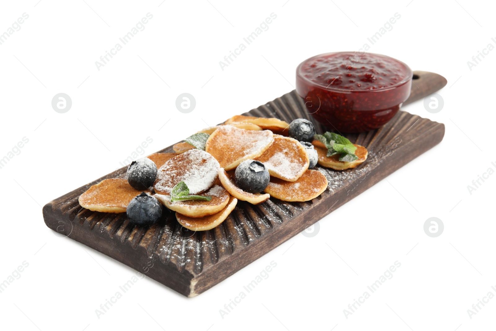 Photo of Wooden board with cereal pancakes, jam and blueberries on white background