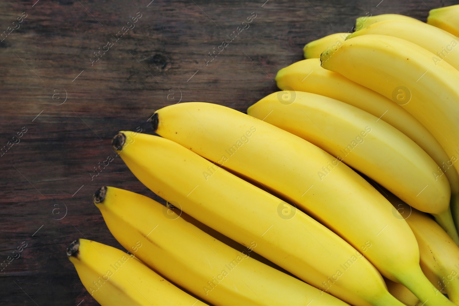 Photo of Ripe yellow bananas on wooden table, flat lay