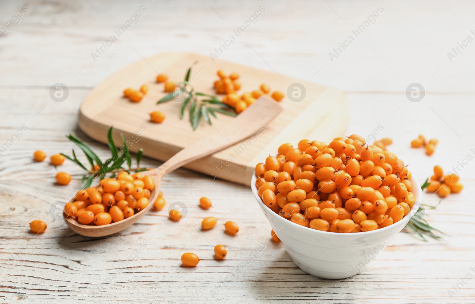 Photo of Fresh ripe sea buckthorn on white wooden table