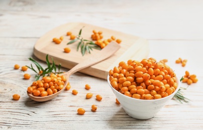 Fresh ripe sea buckthorn on white wooden table