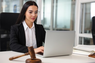 Photo of Focused lawyer working on laptop in office