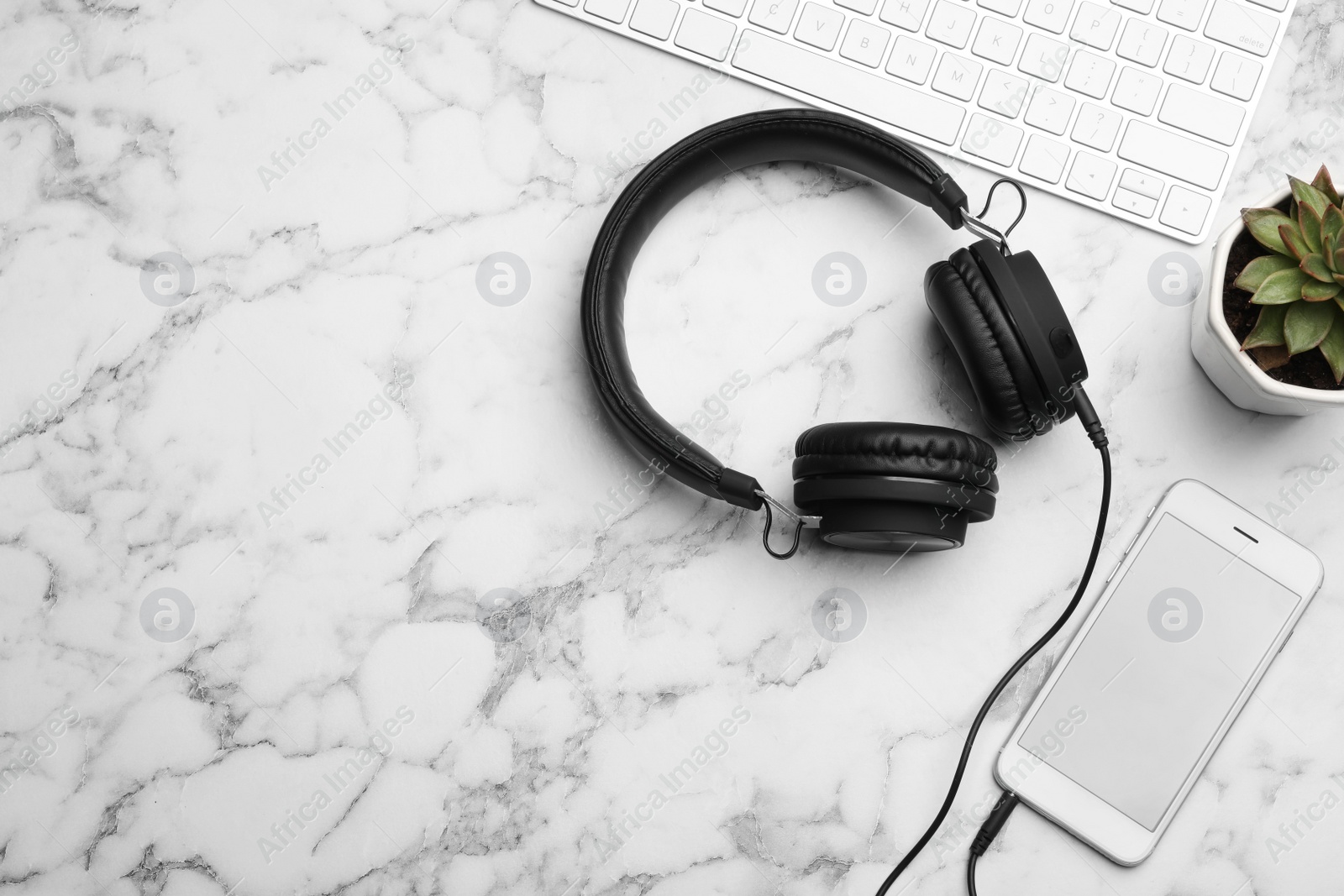 Photo of Flat lay composition with smartphone, computer keyboard and headphones on table. Space for text