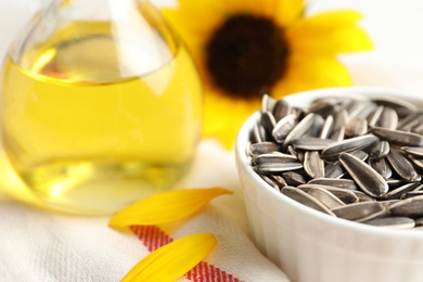 Photo of Organic sunflower seeds and oil on table, closeup