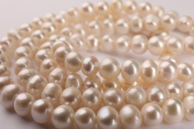 Photo of Elegant pearl necklace on white background, closeup