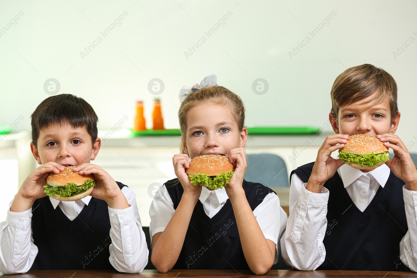 Photo of Happy children eating healthy food for lunch in school canteen