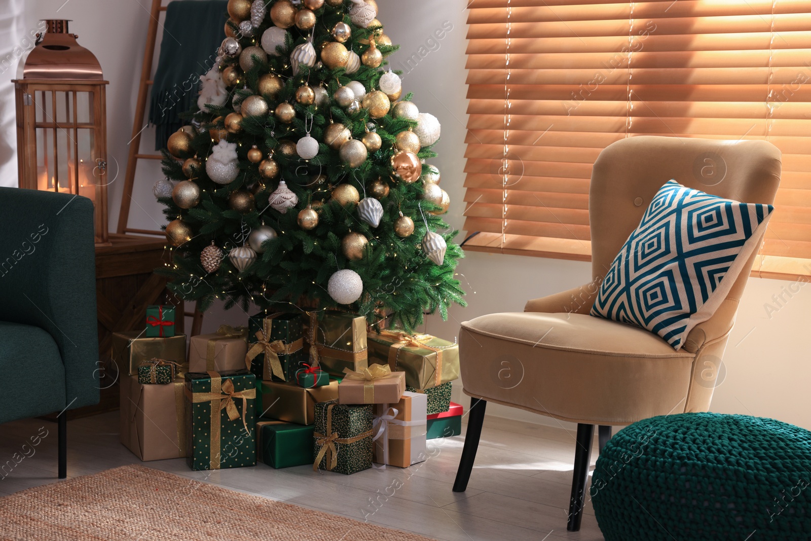 Photo of Armchair near Christmas tree and gift boxes in room