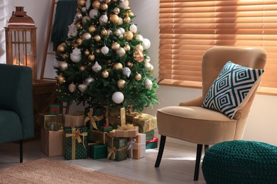 Photo of Armchair near Christmas tree and gift boxes in room