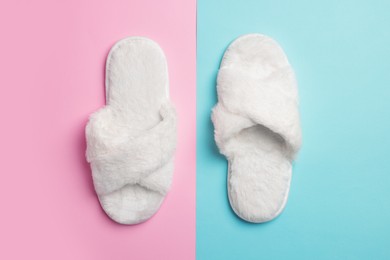 Pair of soft slippers on color background, top view
