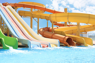 Different colorful slides in water park on sunny day