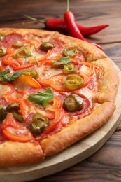 Photo of Delicious pizza Diablo on wooden table, closeup