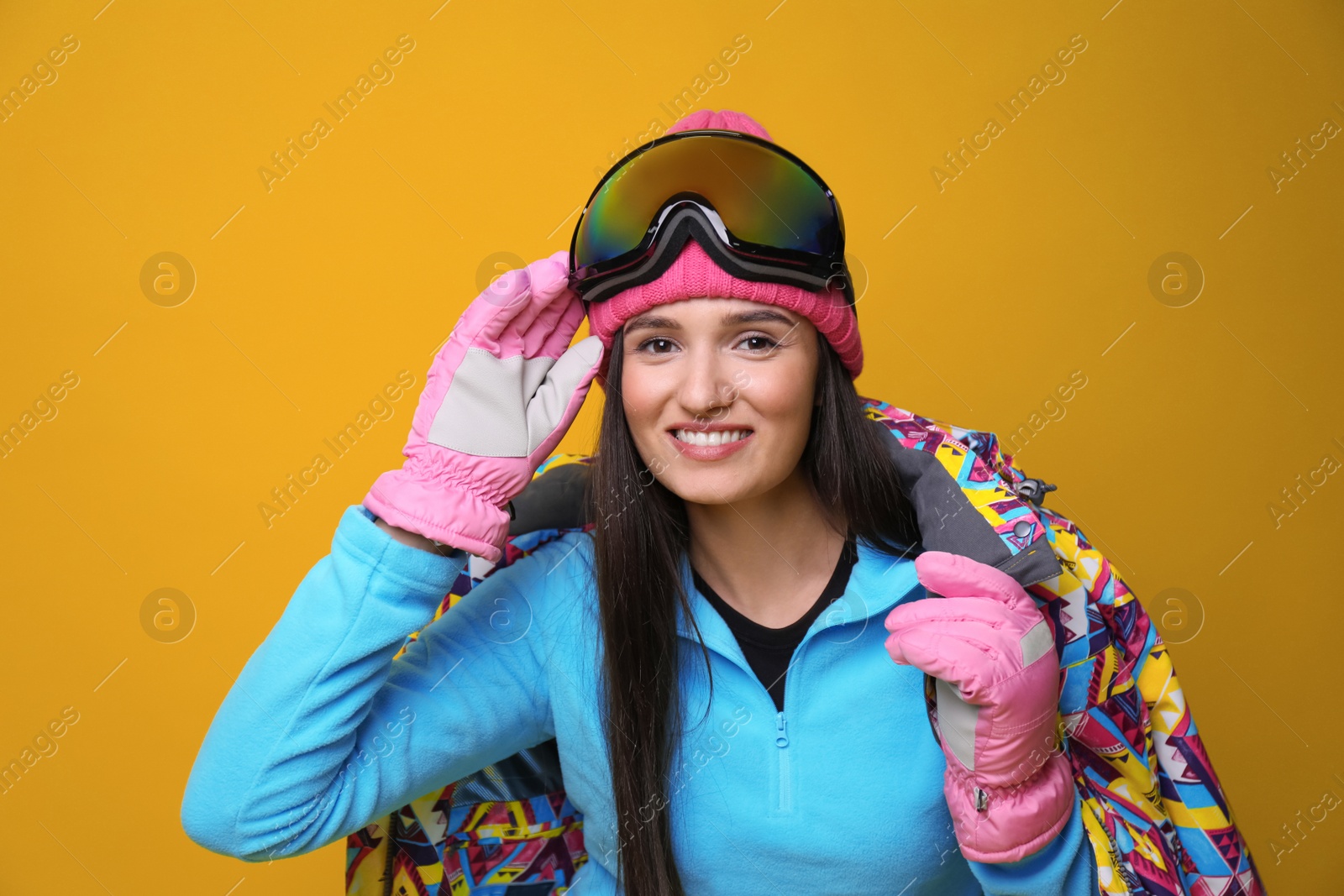 Photo of Woman wearing stylish winter sport clothes on yellow background