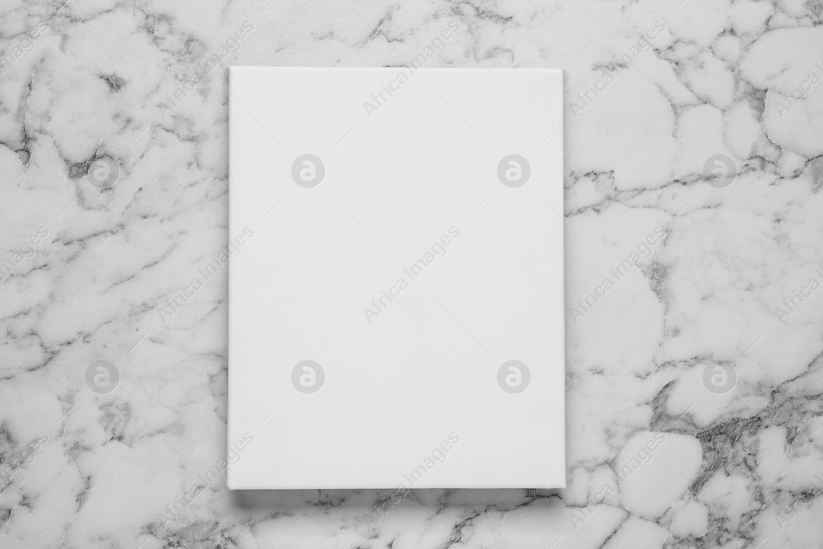 Photo of Blank canvas on white marble background, top view. Space for design