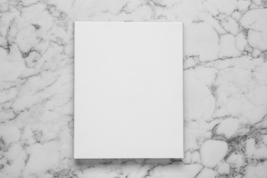 Blank canvas on white marble background, top view. Space for design