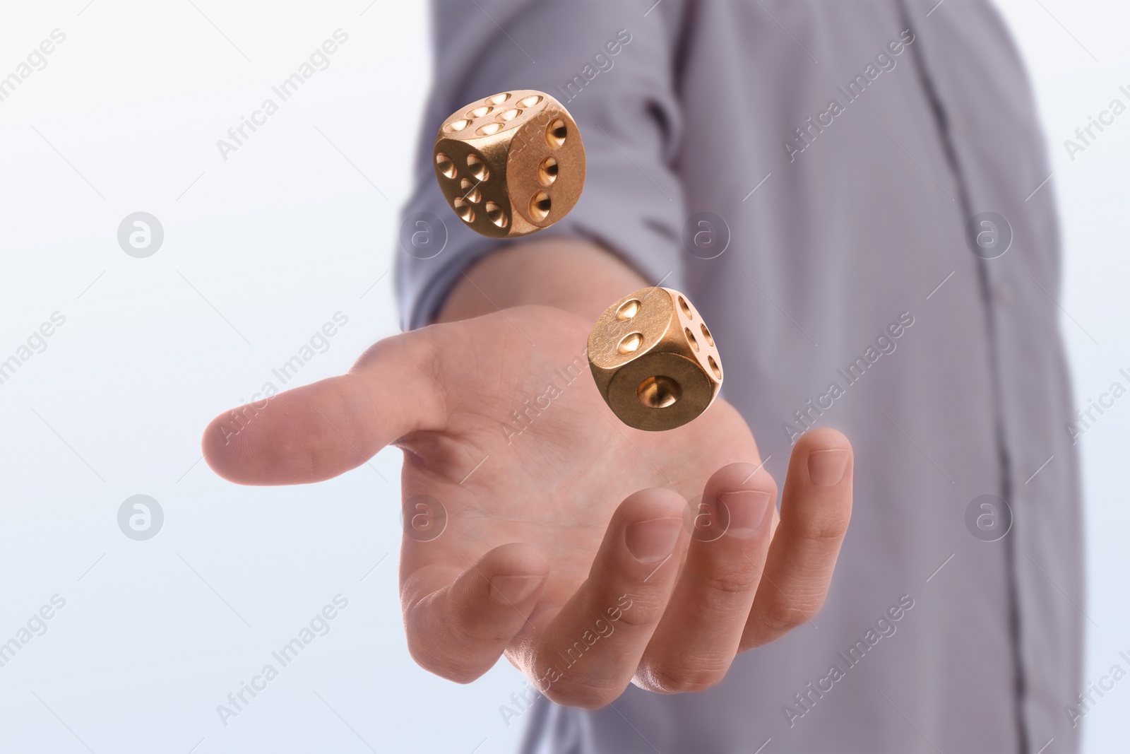 Image of Man throwing golden dice on white background, closeup