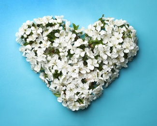 Photo of Heart made of beautiful fresh spring flowers on color background, top view