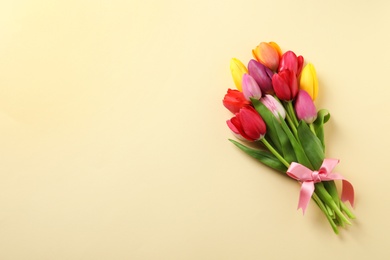 Photo of Beautiful bouquet of spring tulip flowers on color background, top view. Space for text