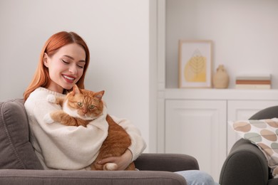 Photo of Happy woman with her cute cat in armchair at home. Space for text