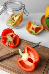 Wooden board with cut paprika pepper on table