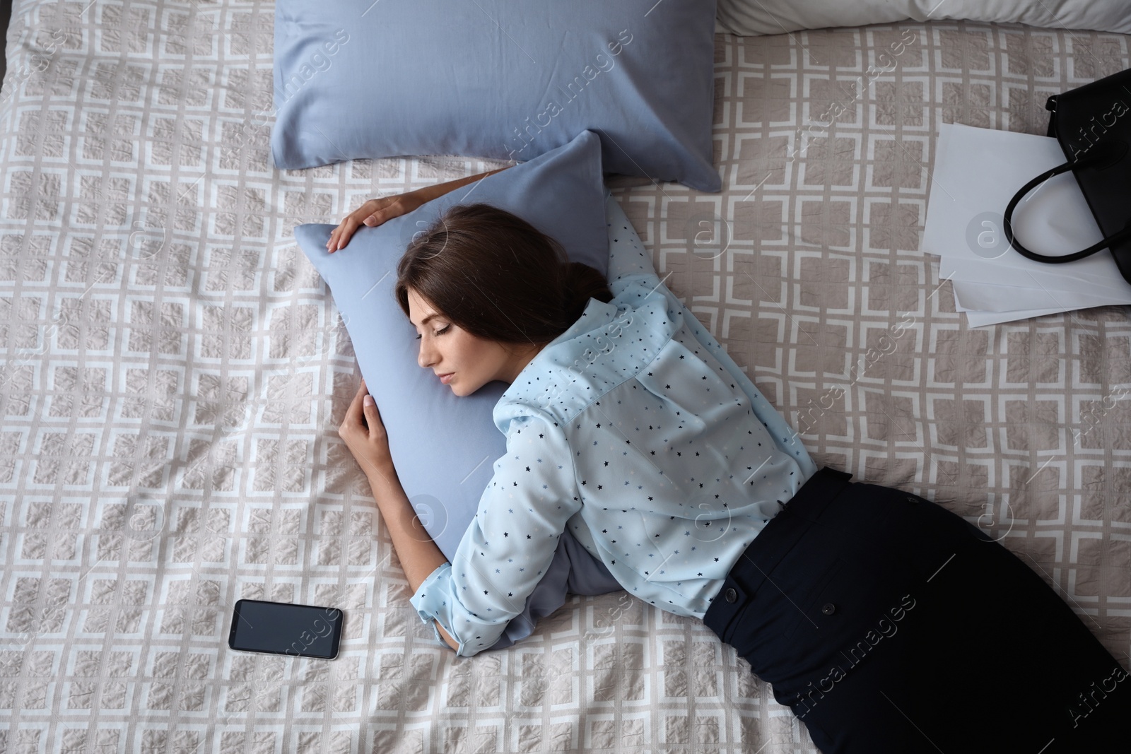 Photo of Exhausted businesswoman in office wear sleeping on bed at home after work, above view