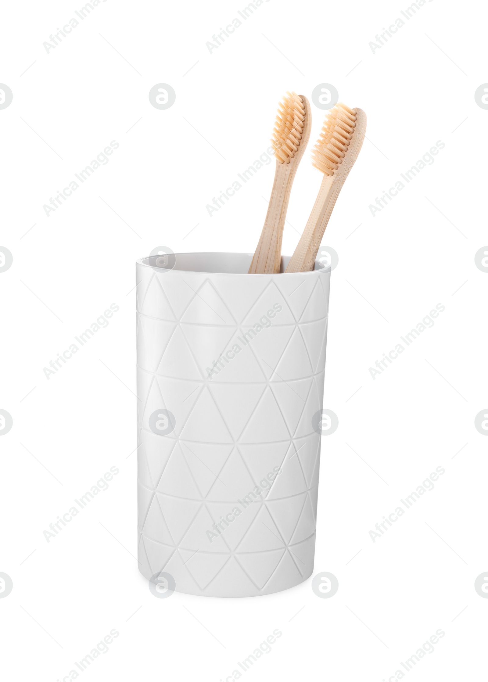 Photo of Bamboo toothbrushes in holder isolated on white